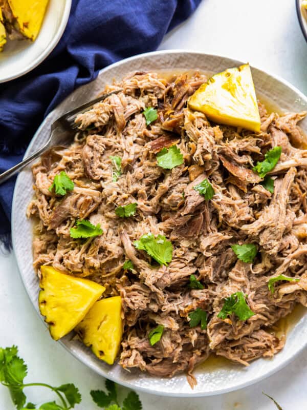 overhead plate of kalua pork on plate with pineapple slices