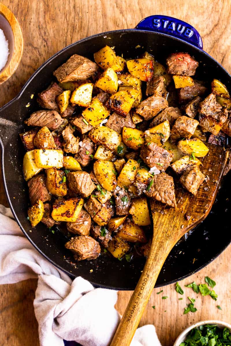 garlic butter steak bites with potatoes in skillet