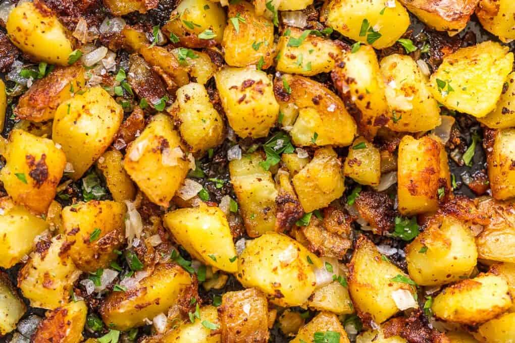fried potatoes in a skillet with onions and parsley.