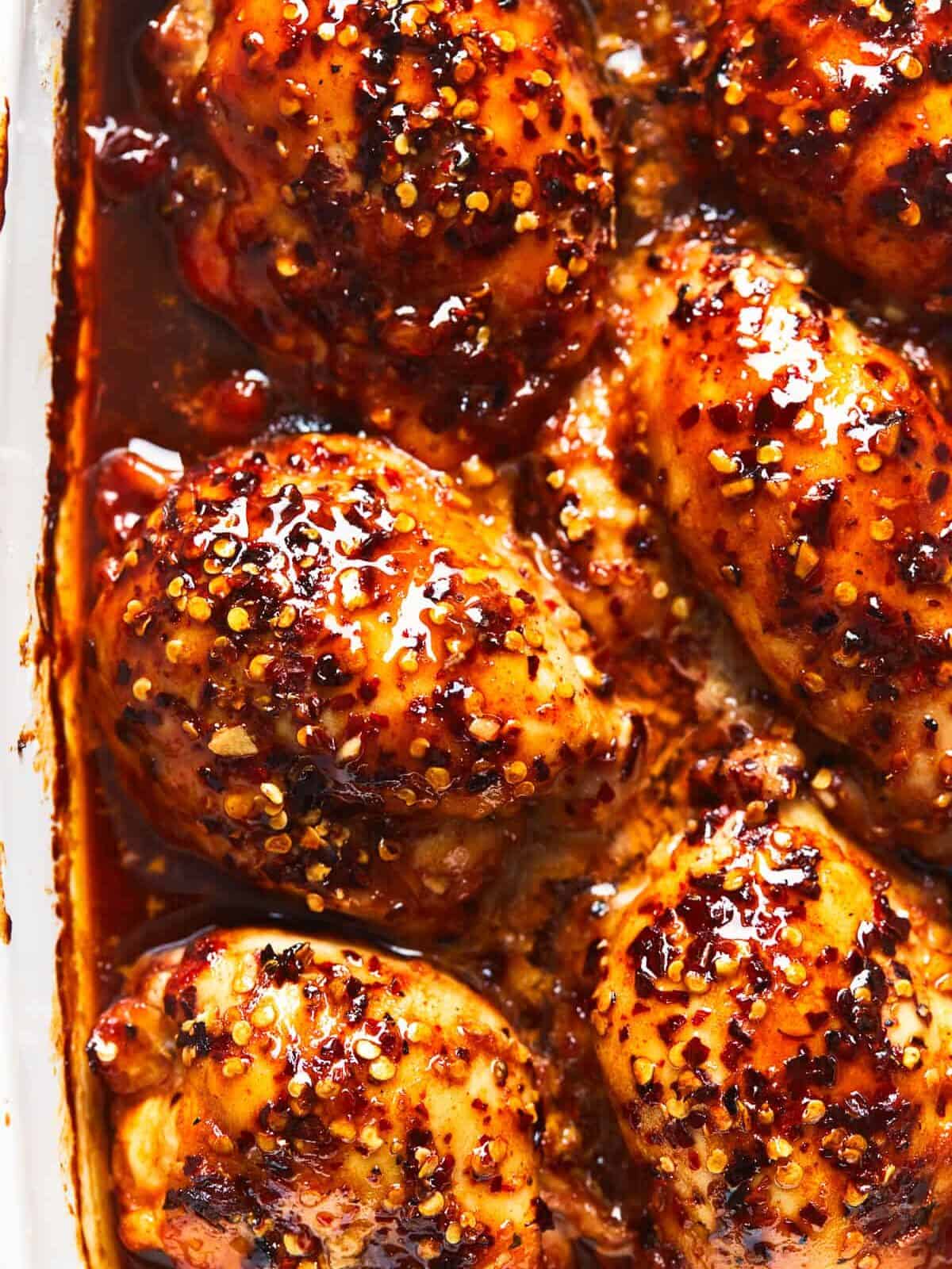 Baked Honey Garlic Chicken is the perfect weeknight dinner! Sweet honey, tangy garlic and spicy red pepper flakes dress up ordinary chicken in this easy dish. Just toss the ingredients together and bake! baked honey garlic chicken thighs in casserole dish