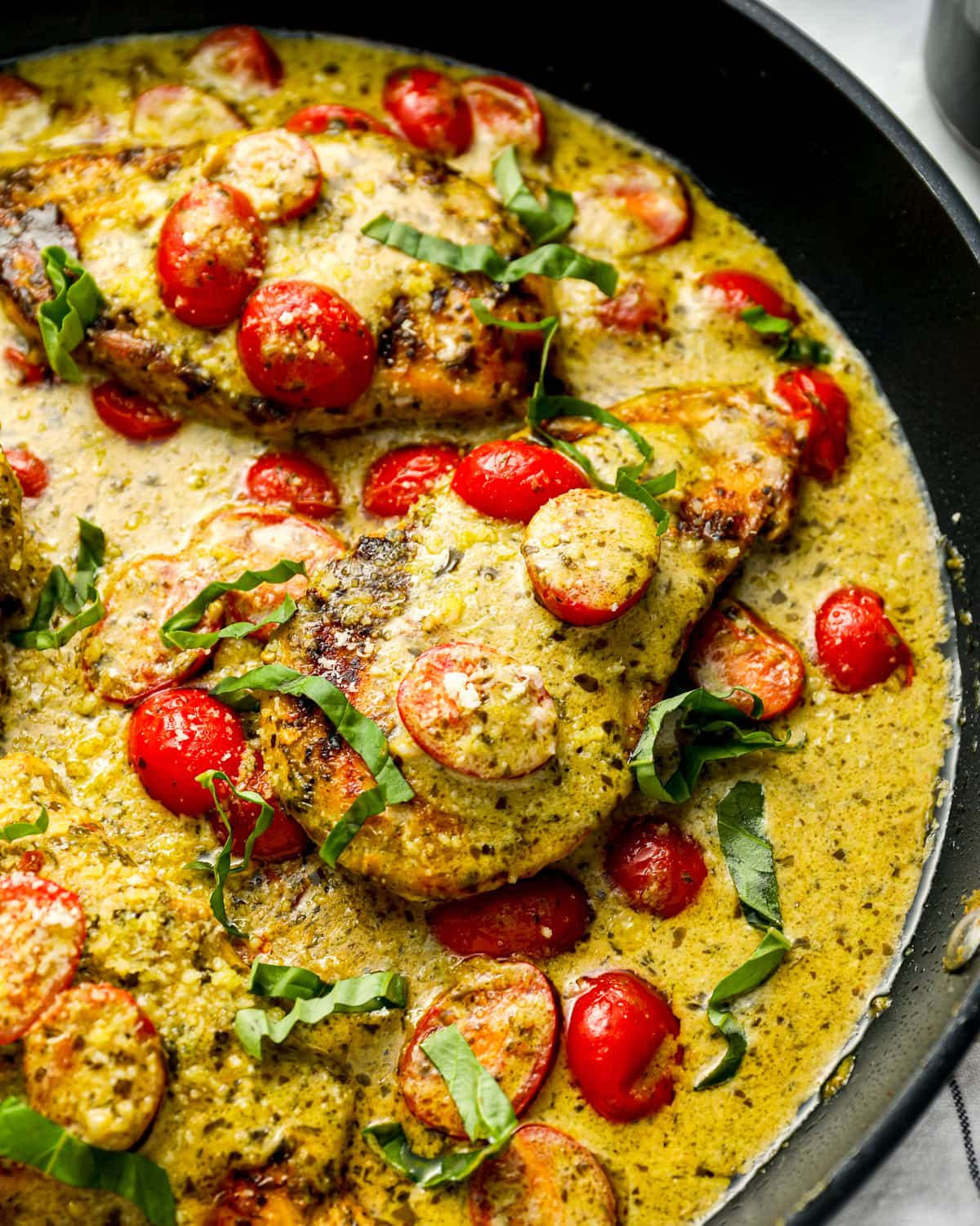 pesto chicken in a skillet.